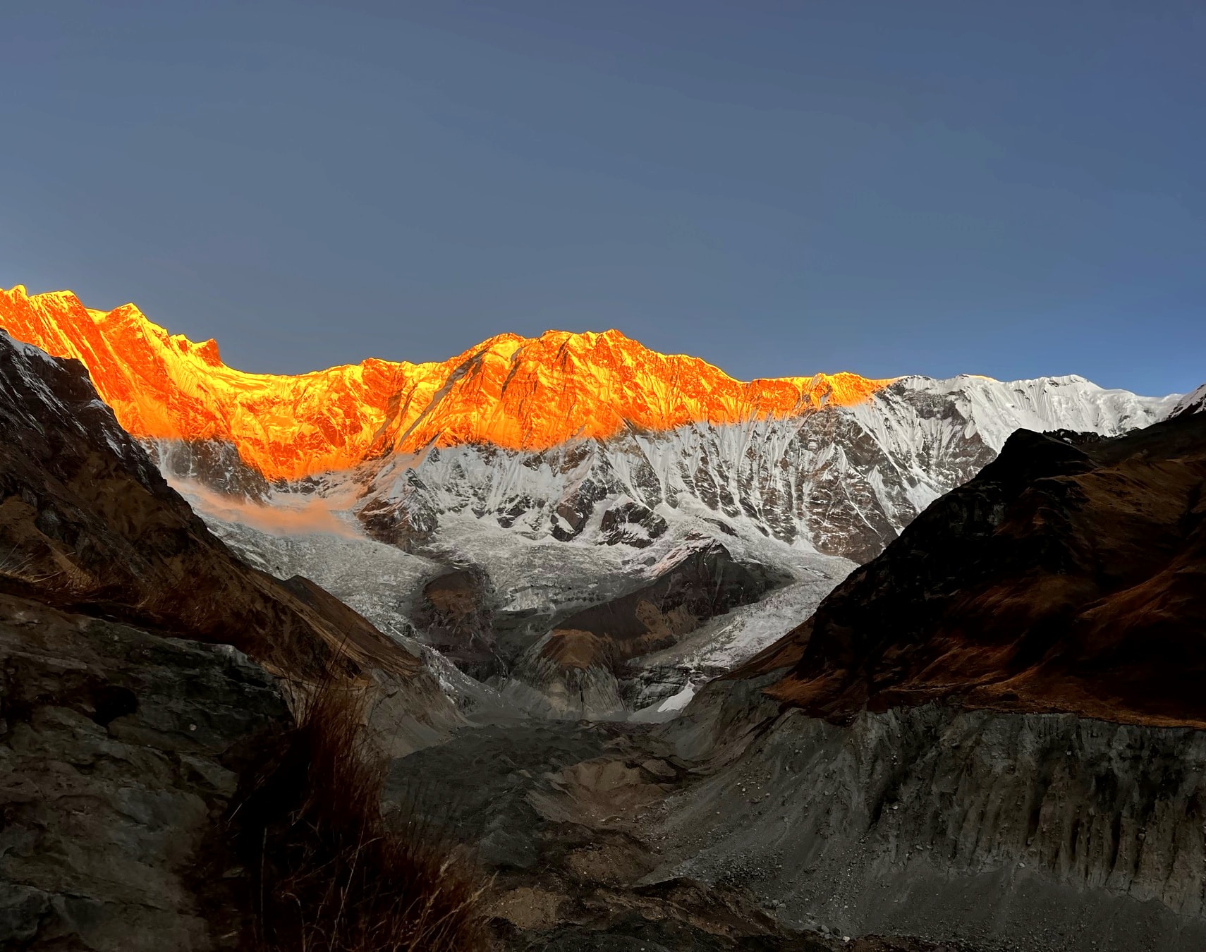 The Annapurna wall lit orange at first light, seen from Annapurna Base Camp